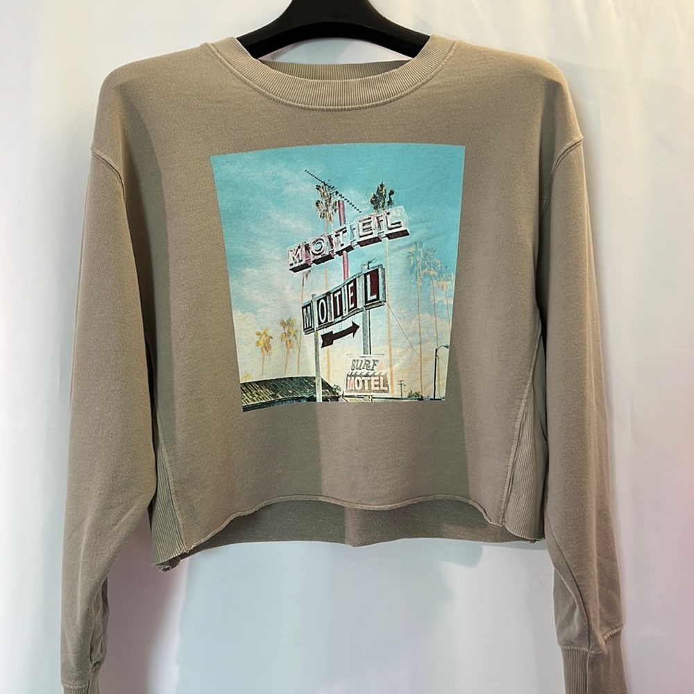 Cropped sandy green crew neck sweatshirt with retro surf motel image